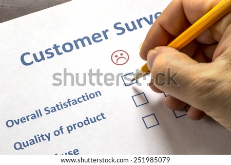Man completing a customer survey with check boxes selecting to show his dissatisfaction