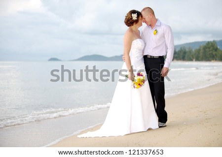 Romantic couple on a beach. Man and woman holding hands and kissing as a romantic couple on a beach