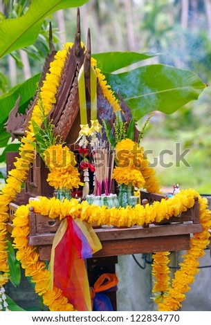 Thai outdoor spirit house shrine. In modern Thailand all spirit houses are kept outdoor. This one is made in the Thai Buddhist temple (wat) style,with Thai teak wood