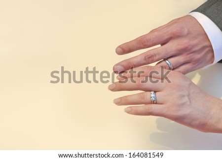 Young couple hands with wedding rings on the space background