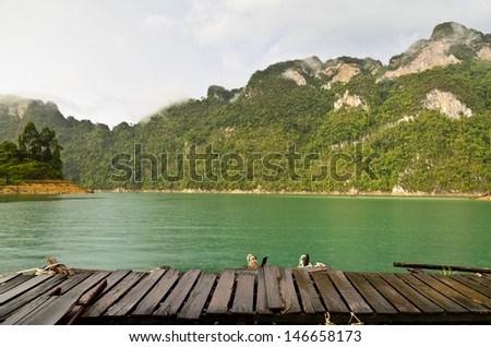 Mountain and river front of the hut while it was raining in Ratchaprapha Dam at Khao Sok National Park, Surat Thani Province, Thailand