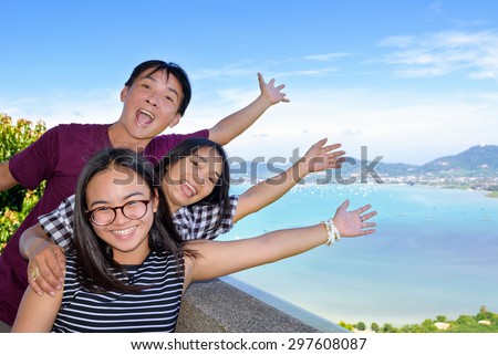 Family of tourists smiling are happy and show their hands invite to see the beautiful landscape of sea on Khao-Khad mountain viewpoint famous attractions in Phuket Province, Thailand