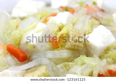 Closeup of Tofu Vegan Soup in a White Bowl with carrots, cabbage and celery
