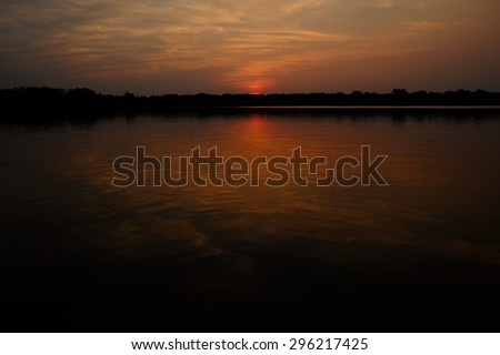 Reflection of clouds in the water as the sun sets on the serene lake
