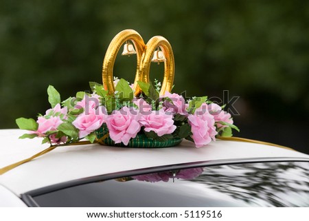 Wedding car decorated with rings, bells and flowers