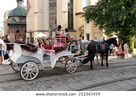 Lvov, Ukraine - CIRCA AUGUST 2013: promenade coach with two harnessed horses running in Lvov