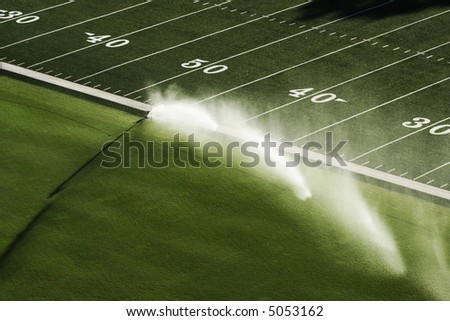 stock-photo-sprinkler-with-a-long-water-jet-in-the-football-stadium-field-5053162.jpg