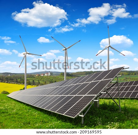 Solar energy panels with wind turbines in spring landscape