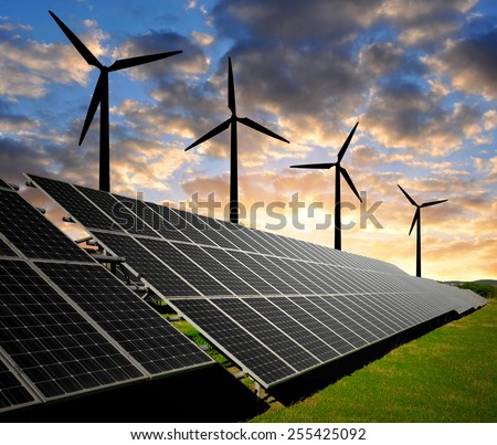 solar energy panels and wind turbines in the sunset