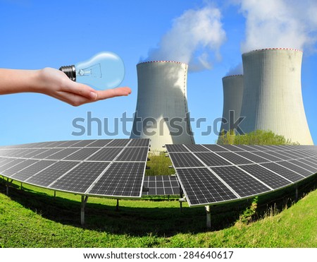Solar energy panels with nuclear power plant and bulb in hand.