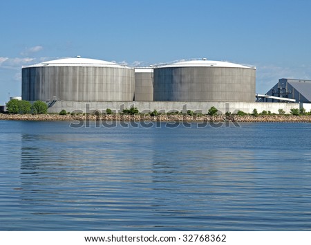 three circular industrial tanks built near the coast