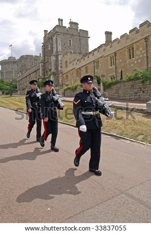 WINDSOR, ENGLAND - JULY 6: Marching Foot Guards at Windsor Castle, England, July 6, 2009. Windsor is the most inhabited castle in the world. The Foot Guards are infantry regiments of the British Army.