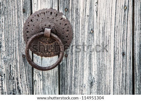 Metal door knob-knocker on the old rustical door. Greece. Crete. One of the abandoned house in Rethymnon city.