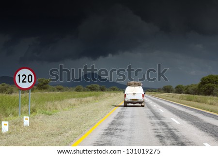 Single safari car traveling in Africa. Namibia. Dark, storm sky.
