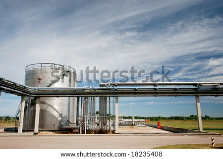industrial pipelines and storage tank against blue sky