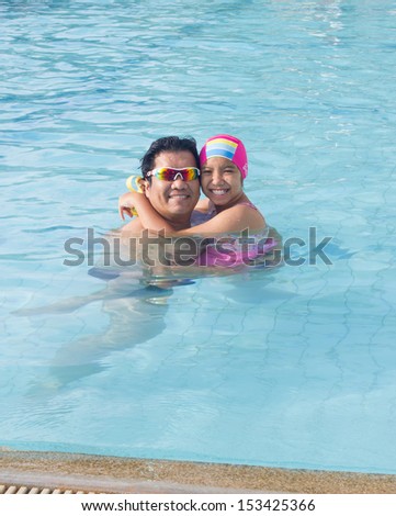 Asian dad and daughter in the swimming pool