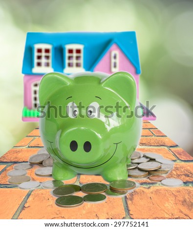 piggy bank with coins at the back ,concept of save for home