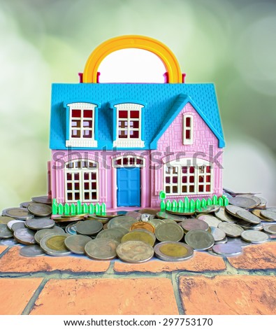Toy small house standing on a heap of coins,The concept of saving for house