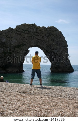 A man stood in the arch of Durdle Door in Southern England