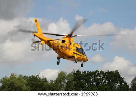 A bright yellow air ambulance just taking off