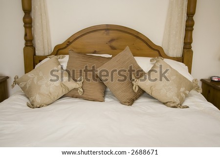 Natural colored pillows on a wooden framed bed