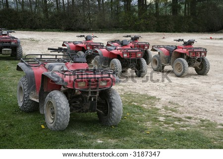 A group of dirty quad bikes waiting to be ridden