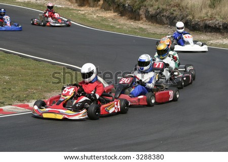 A procession of go karts racing around a bend