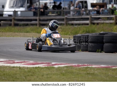 An adult racing go-kart coming out of a bend.