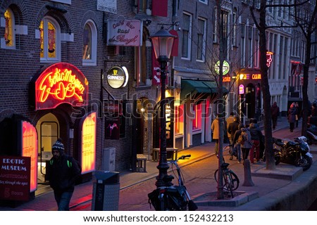 AMSTERDAM, NETHERLANDS - MARCH 26: Red light district at night on March 26, 2013 in Amsterdam. Red light district is a part of city Amsterdam where is a lot of prostitution and sexoriented businesses.