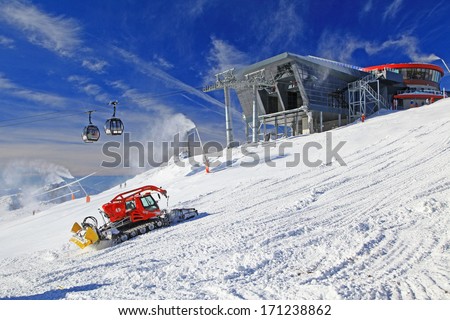 JASNA, SLOVAKIA - JANUARY 13: Modern cableway and groomer on the hill Chopok in ski resort Jasna - Low Tatras mountains on January 13, 2014 in Jasna