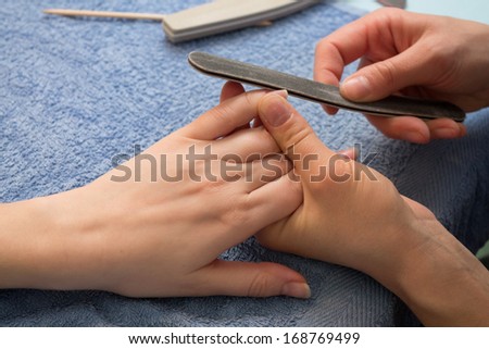 manicurist shapes the nails with nail file