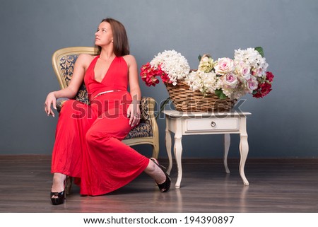 girl in red dress posing on  chair near vintage tables