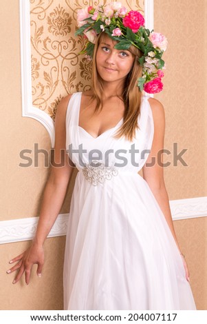 portrait girl with wreath on his head on background of beige classic wall