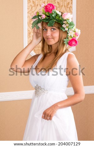 portrait girl with wreath on his head on background of beige wall