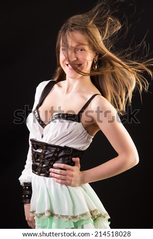 wind blows the girl\'s hair in original dress in studio