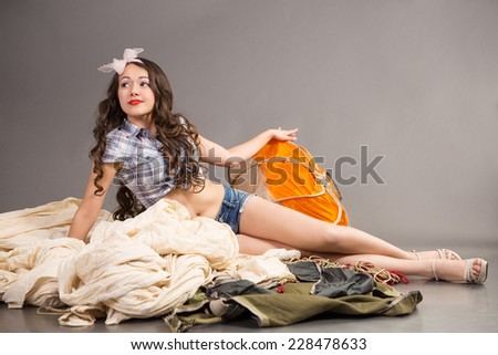 brunette with long hair in short shorts, shirt and bow on head lies on dissolution of the old parachute