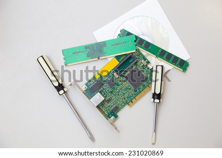 network card, two  screwdrivers, RAM and disk On table top view