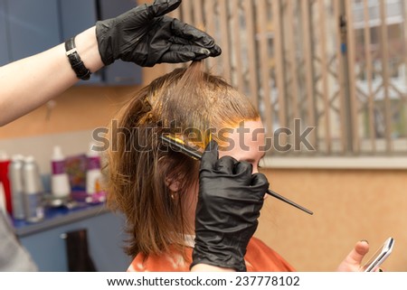 Barber in disposable gloves colors roots hair red
