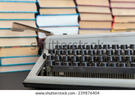 old typewriter on background of a pile of books