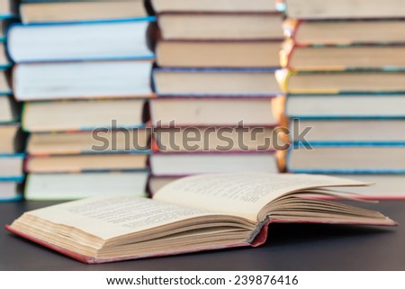 Opened red book on a background of a pile of books