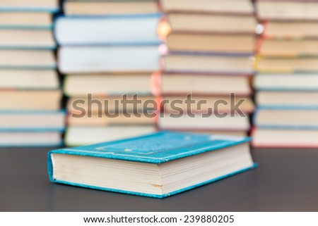 book cover in blue on a background of books