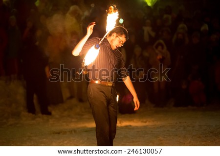 Perm, Russia - January 17, 2015. man twists fiery stick without hand on shoulder