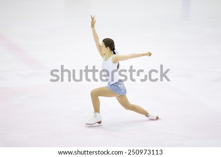 Perm, Russia - January 31, 2015. Figure skating competitions among fans. Girl in a denim skirt and white shirt makes sliding member skating