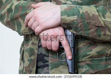 gun in hand of man in military clothing