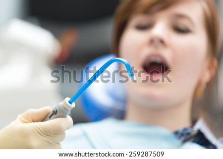 saliva ejector on background woman
