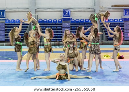 Perm, Russia - March 28, 2015. Championship Perm Krai on cheerleading. Girls in savages suits  make  pyramid with element of arabesque and twine to compete in cheerleading