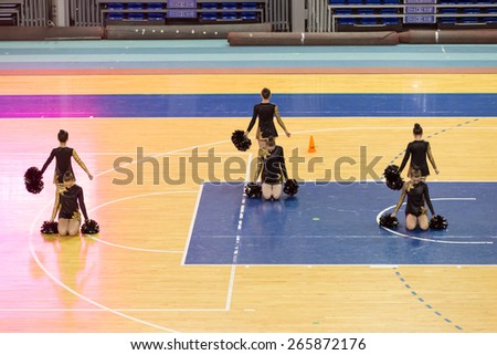 Perm, Russia - March 28, 2015. Championship Perm Krai on cheerleading. Cheerleading team in black and gold costume dancing