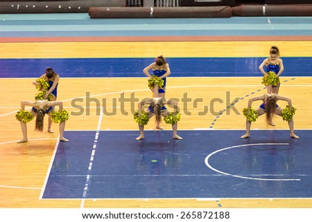 Perm, Russia - March 28, 2015. Championship Perm Krai on cheerleading. Cheerleading team in blue costume with gold pompons dancing