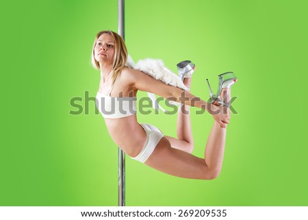 sexy girl in white shorts and angelic wings makes  element yogini  at pole dance