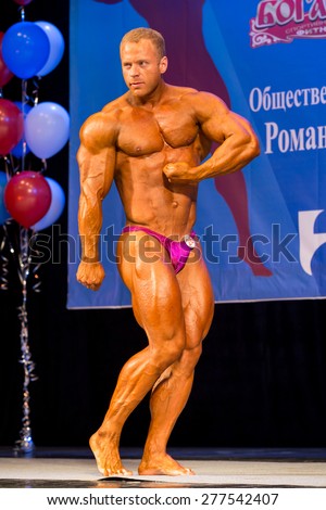 Perm, Russia - April 19, 2015.Cup Perm Krai  on bodybuilding and fitness bikini. Muscular man in pink  briefs showing  biceps and triceps
